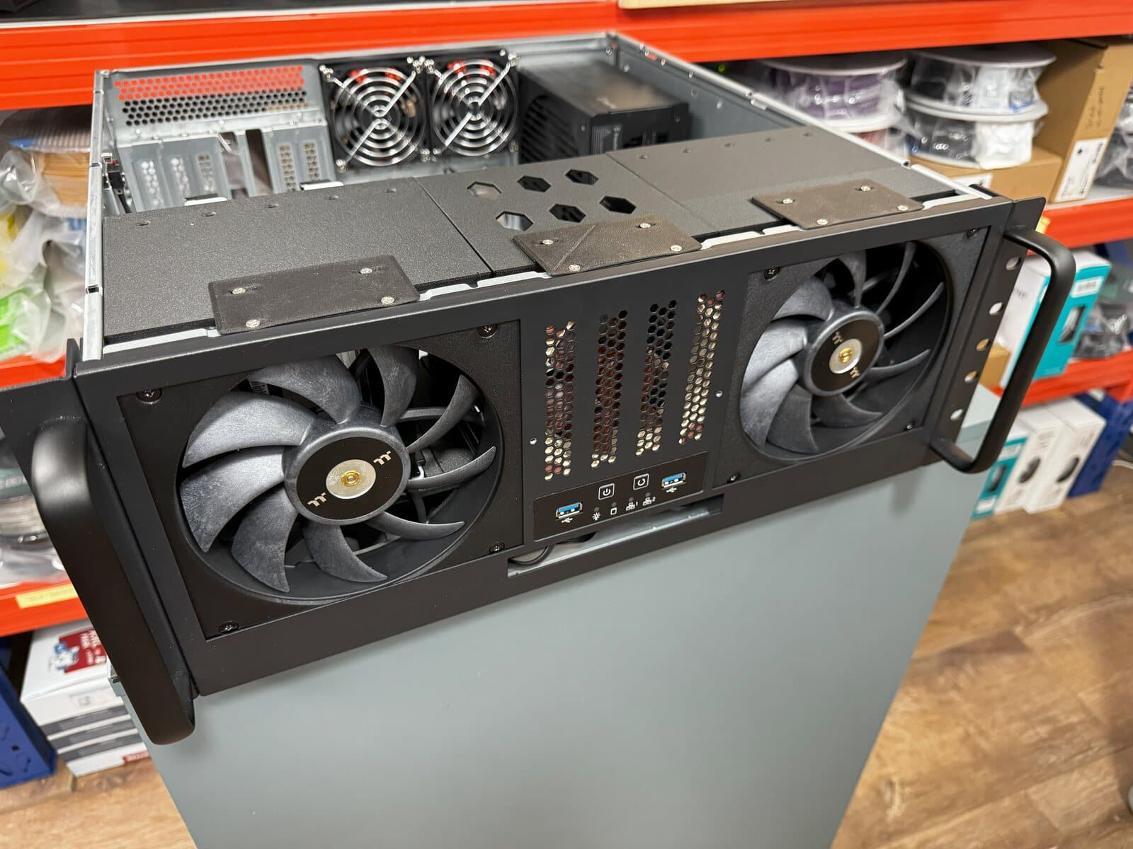 Short-depth 4U rackmount server chassis with custom 3D printed front drive cages and large intake fans.